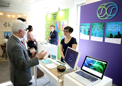 UW-Stout Provost Patrick Guilfoile, left, talks with a student about her project at the Senior Show in May. 