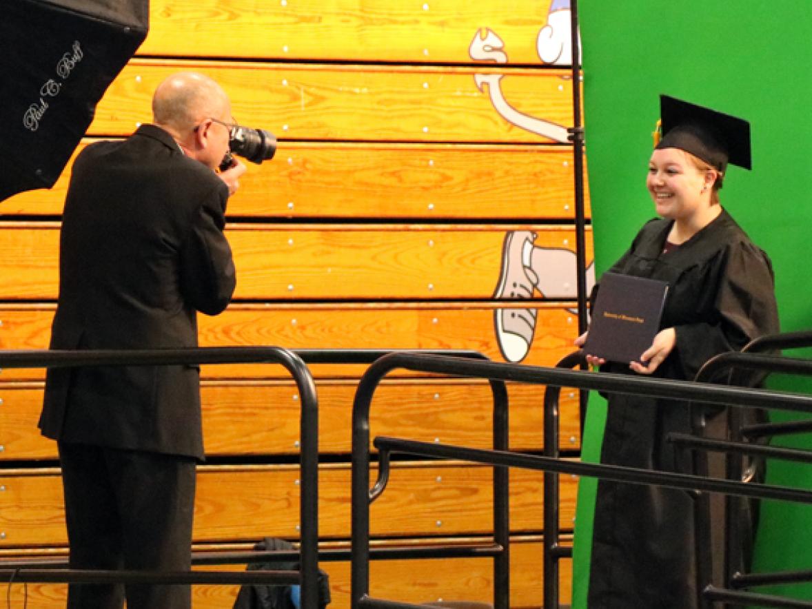 Brittany Jordan has her photo taken after crossing the stage at commencement.
