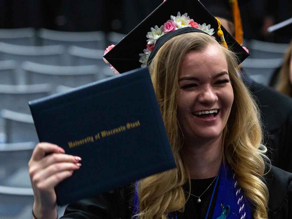 A graduate celebrates after receiving her diploma in December 2019.