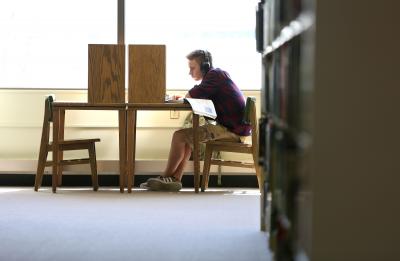 Student studying a desk in the library.