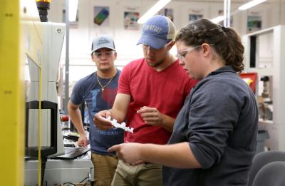 A lab section of Professor Adam Kramschuster's Injection Molding Theory, Design and Application class is photographed in the Plastics Engineering lab in Jarvis Hall Tech Wing.