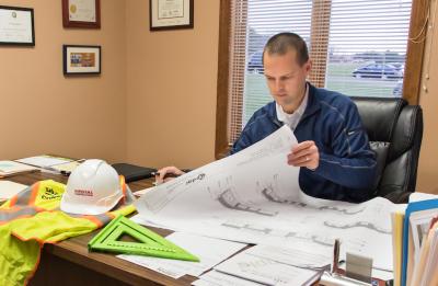 President/CEO Jim Bunkelman of Royal Construction, Inc. looks at blue prints for a construction project as he works at the office in Eau Claire, Wisconsin.