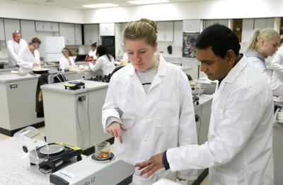 UW-Stout Assistant Professor Pranabendu Mitra works with a student in a food science lab.